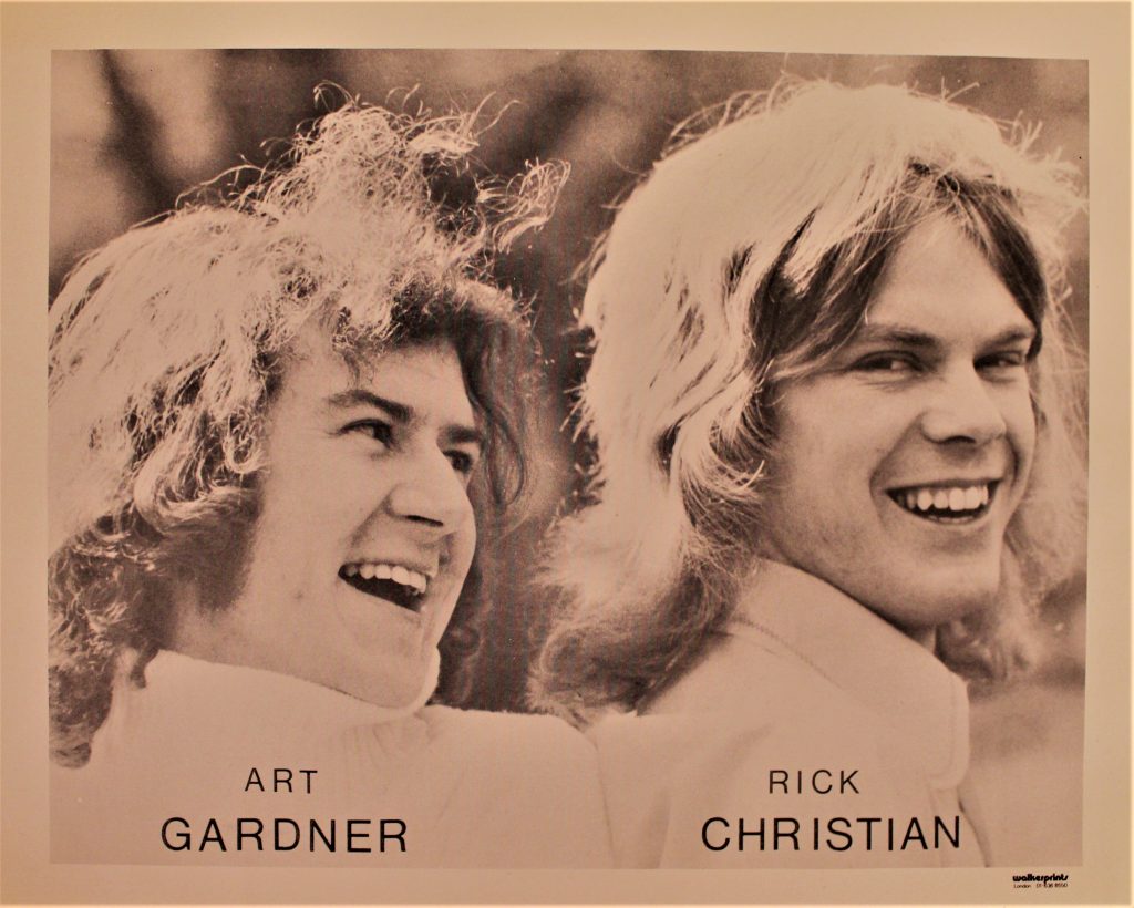Poster for the Art Gardner and Rick Christian, with black text overlaid on a black and white photograph of the duo. Both men are smiling, with long hair.