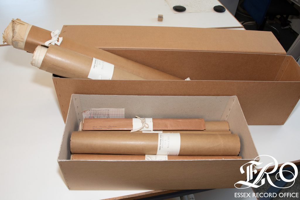 Bundles of rolled plans wrapped in brown paper in brown boxes