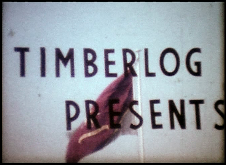 Still from a cine-film with the title 'Timberlog Presents' across the image of a red flag flying against a blue sky.
