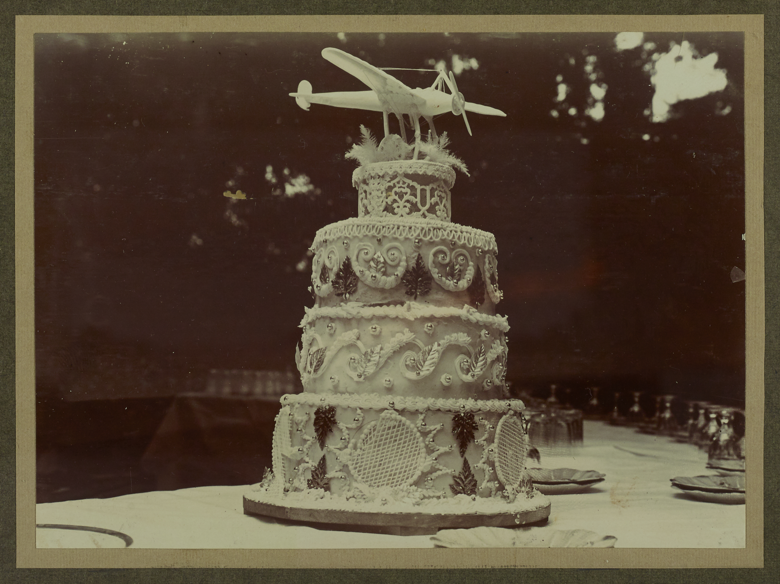 Ornate, four tiered cake topped with a model aeroplane