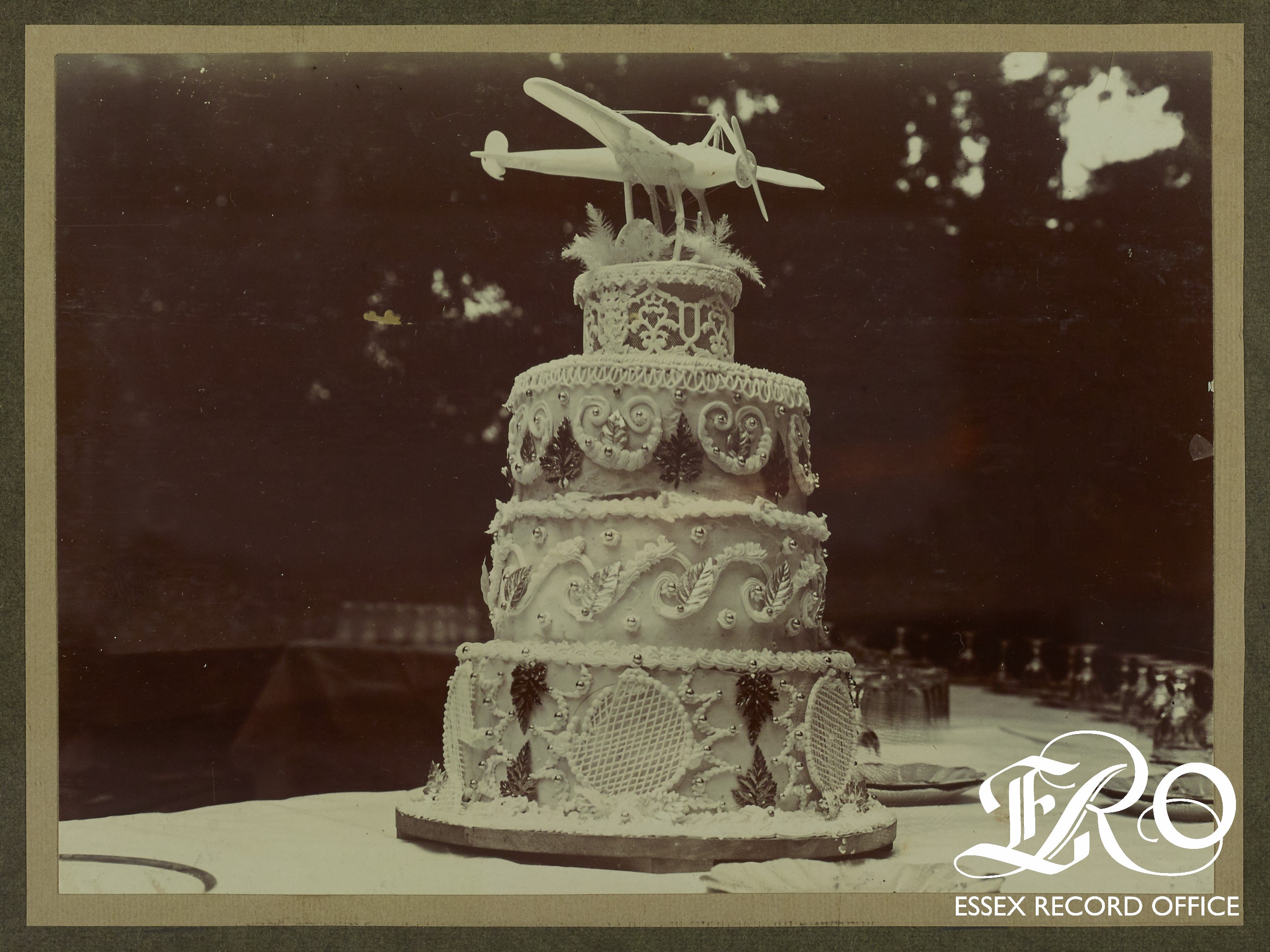 Ornate, four tiered cake topped with a model aeroplane